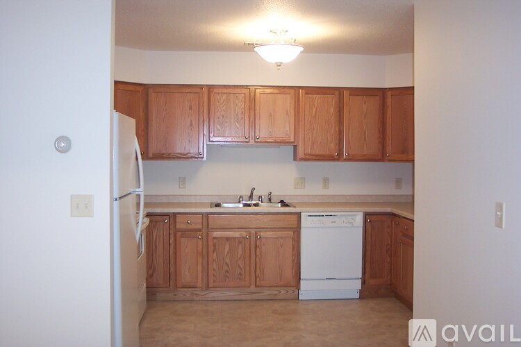 A kitchen with wooden cabinets and a white dishwasher.