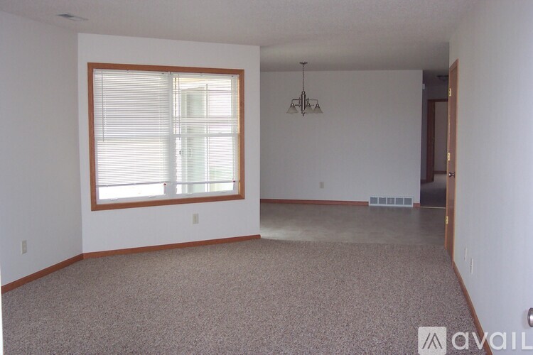 A room with a window and a chandelier.