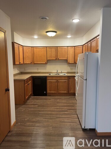 A kitchen with wooden cabinets and a white refrigerator.