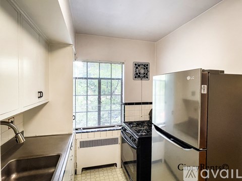 A kitchen with a stainless steel refrigerator and a sink.