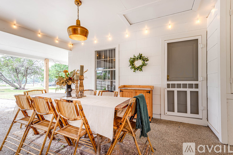 A dining room with a table set for six and a wreath on the wall.