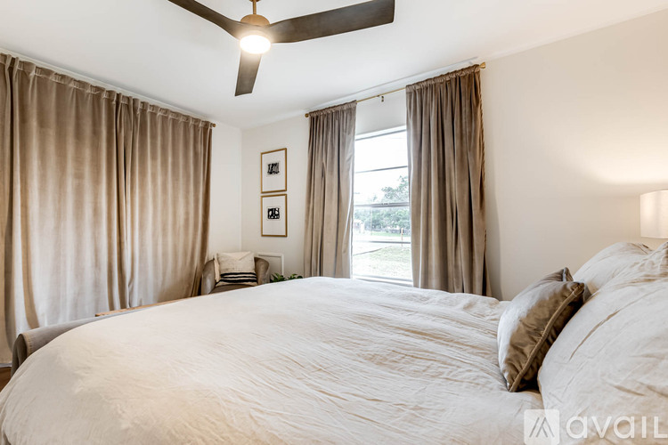 A bedroom with a large bed and a ceiling fan.