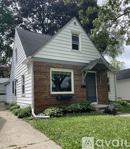 A small house with a grey roof and a white front porch.