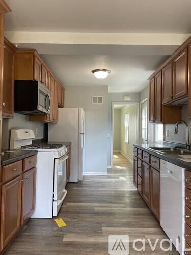 A kitchen with wooden cabinets and white appliances.