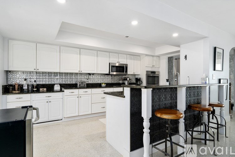A kitchen with black countertops and white cabinets.