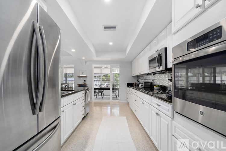 A modern kitchen with stainless steel appliances and white cabinets.