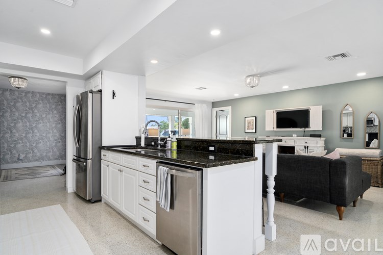 A modern kitchen with stainless steel appliances and white cabinets.
