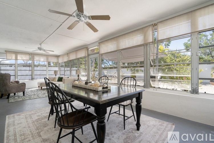 A dining room with a table and chairs and a ceiling fan.