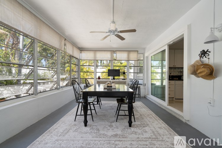 A dining room with a table and chairs and a ceiling fan.