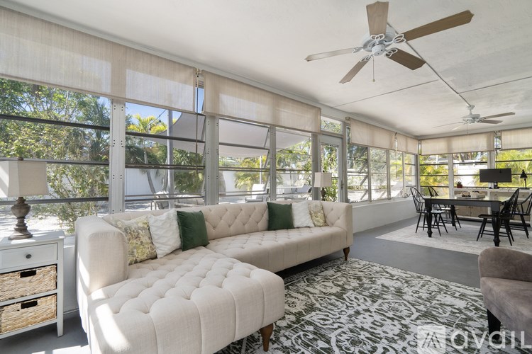 A living room with a white couch and a ceiling fan.