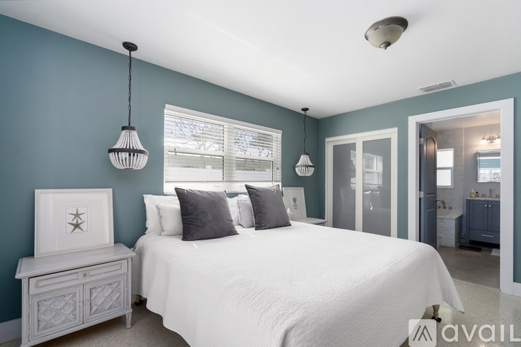 A bedroom with a white bed and a white nightstand with a star design on it.