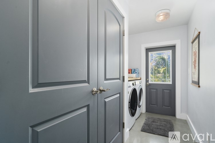 A laundry room with a washer and dryer and a door leading to a balcony.