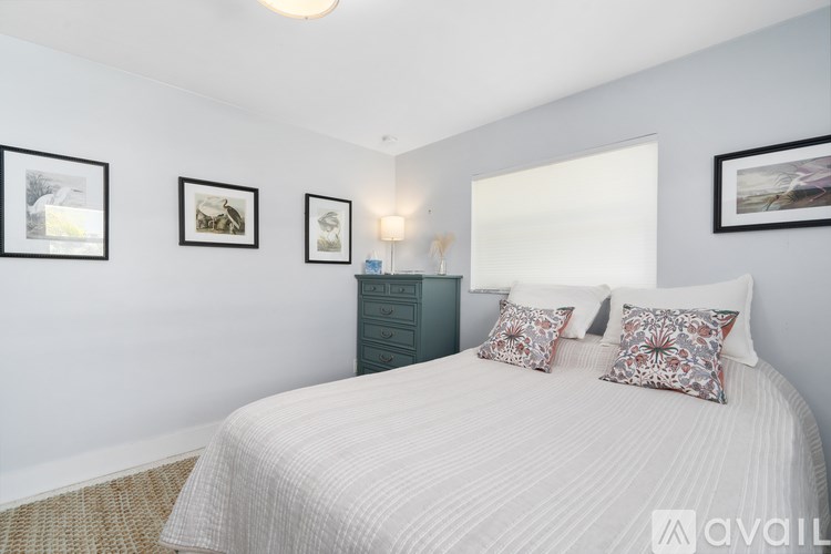 A bedroom with a white bed and a green dresser.