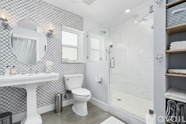 A white toilet sits in a bathroom with a glass shower stall.