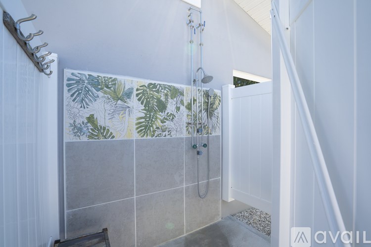 A bathroom with a shower area and a glass door.