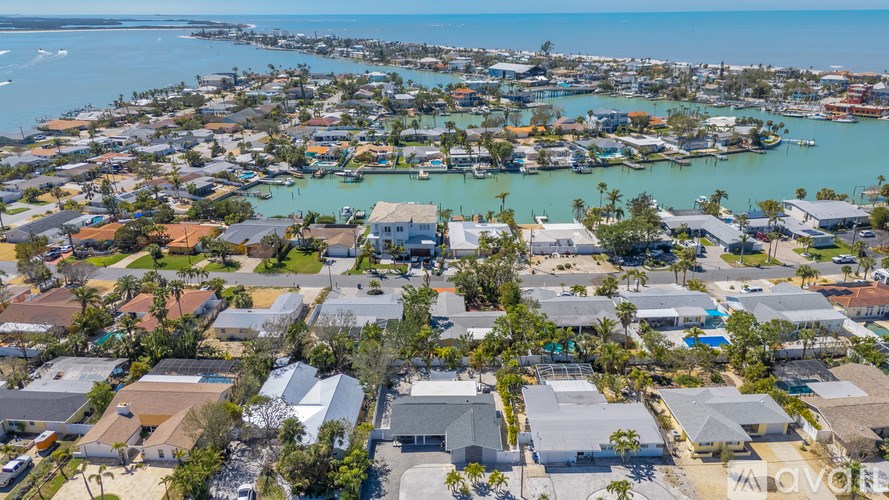 A bird's eye view of a residential area with houses and a body of water.
