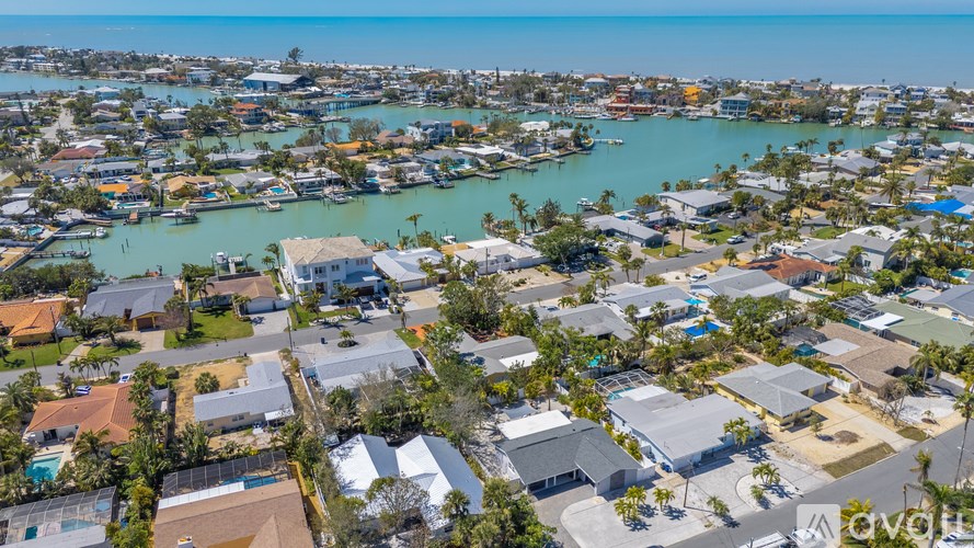 A bird's eye view of a coastal residential area with houses and boats.