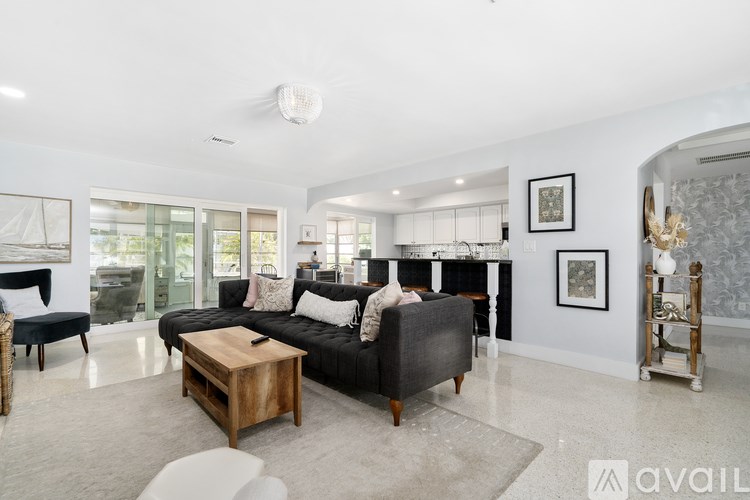 A living room with a black couch and a wooden coffee table.