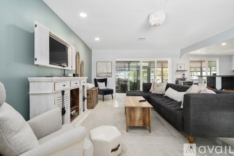 A modern living room with a grey couch and a white chair.