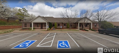 A parking lot with a building and two handicap parking spaces.