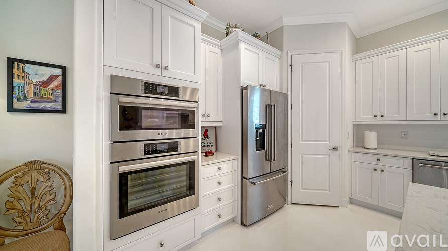 A kitchen with white cabinets and stainless steel appliances.