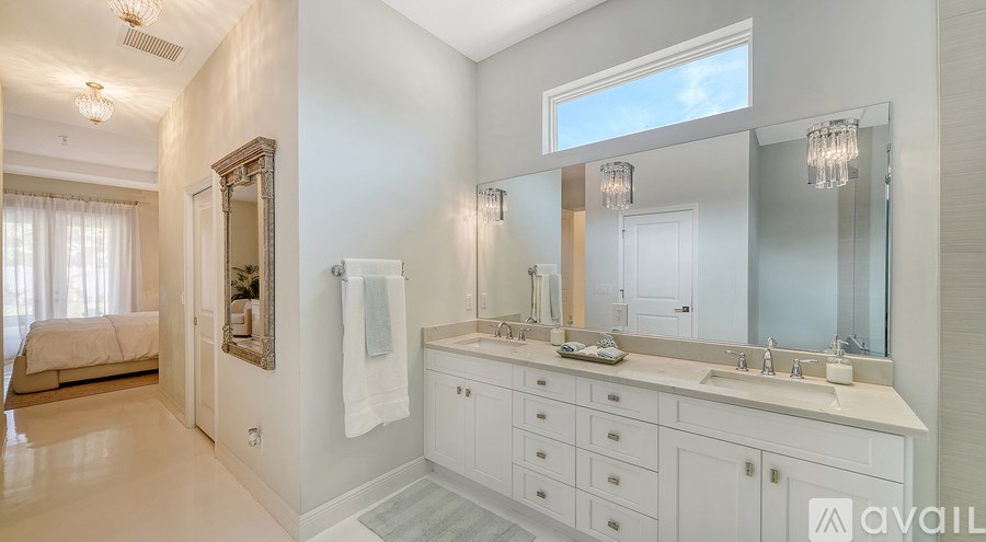 A bathroom with a large mirror and a vanity with a sink.