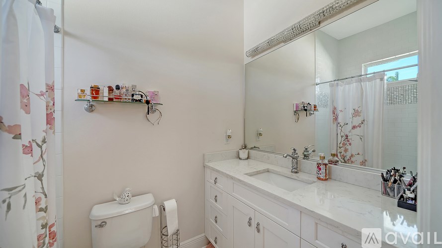 A white bathroom with a toilet, sink, and mirror.