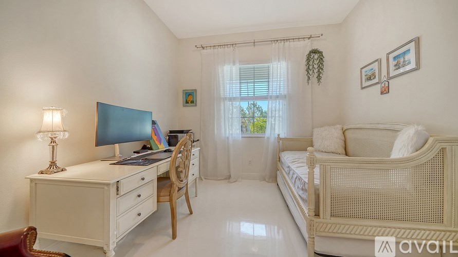 A well-lit bedroom with a bed, desk, and chair.