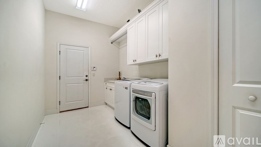 A white kitchen with a microwave oven and a door.