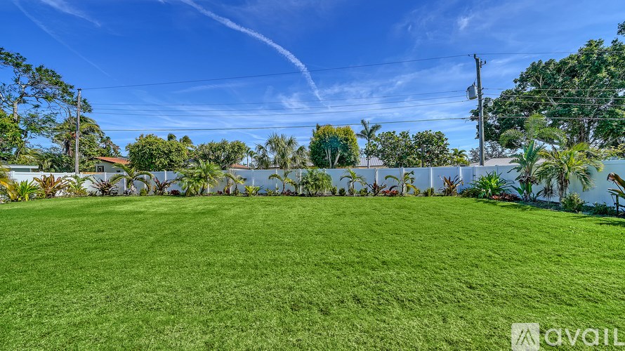 A large, well-maintained lawn with a clear blue sky above.
