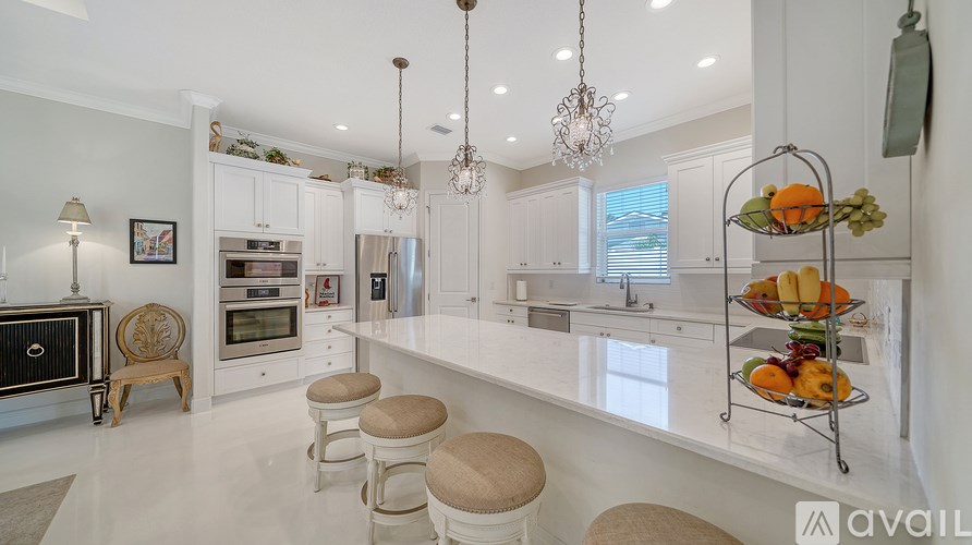 A modern kitchen with white cabinets and a large island.