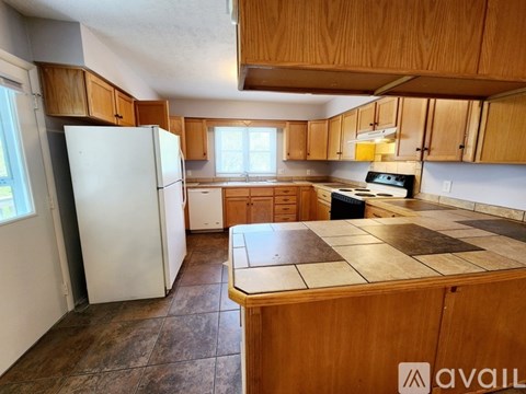 A kitchen with wooden cabinets and a white refrigerator.