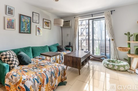 A living room with a green sofa and a patterned blanket.