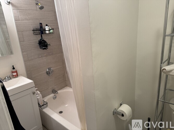 A bathroom with a white tub and a white sink.