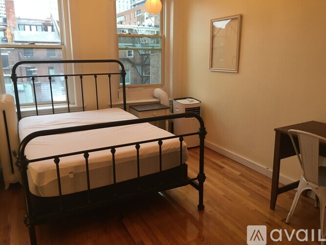 A bedroom with a large bed and a desk.