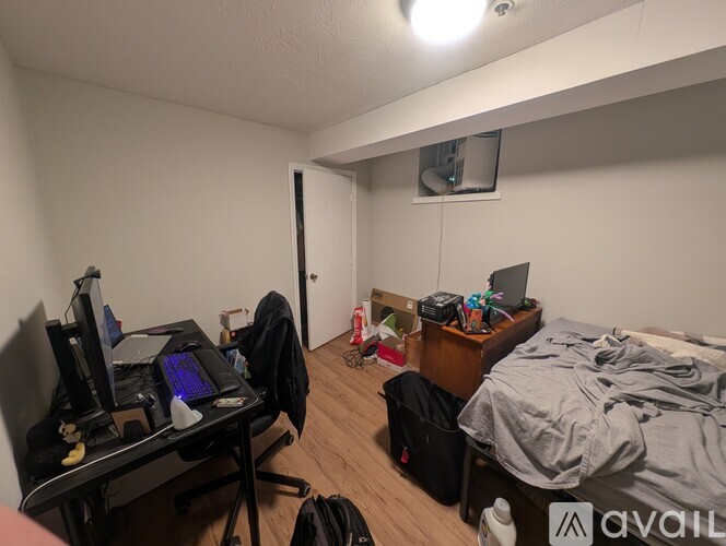 A room with a bed, desk, and computer setup.