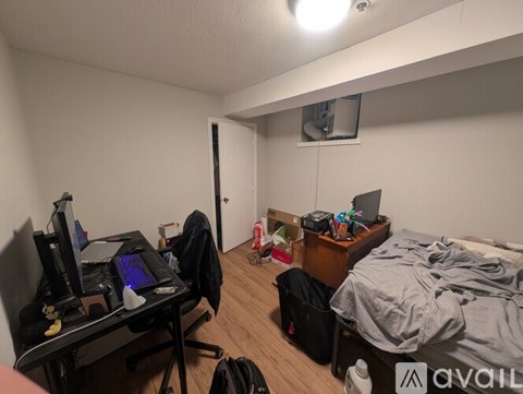 A room with a bed, desk, and computer setup.