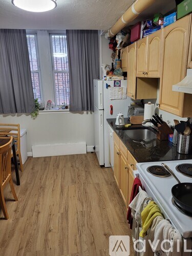 A kitchen with wooden floors and a white refrigerator.