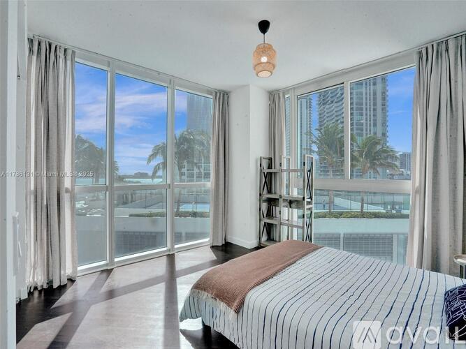 A bedroom with a large bed and a view of the outside.