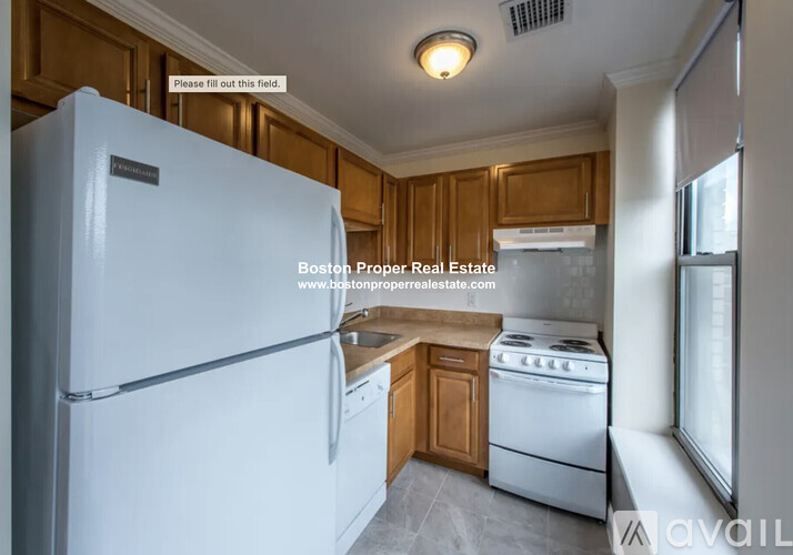 A kitchen with a white fridge and wooden cabinets.