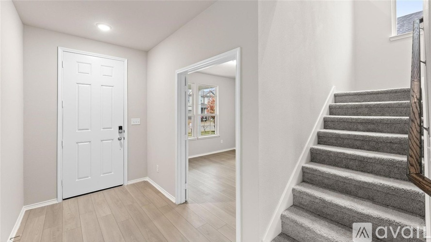 A hallway with a staircase leading to the second floor.