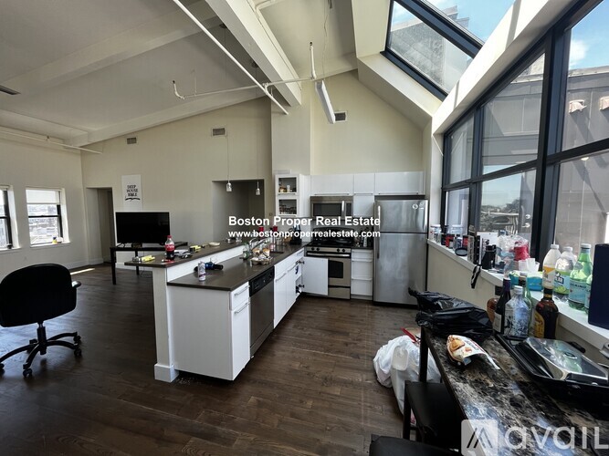 A modern kitchen with a large island and a refrigerator.