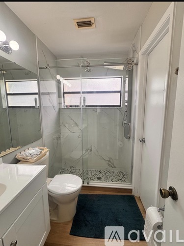 A bathroom with a toilet, sink, and shower.