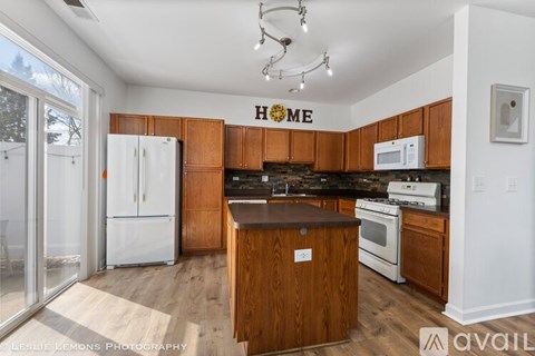 A kitchen with wooden cabinets and a white fridge.
