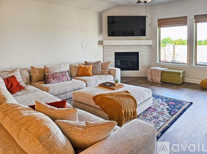 A living room with a grey couch and a fireplace.