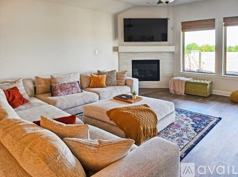 A living room with a grey couch and a fireplace.