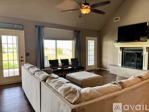 A living room with a long couch and a ceiling fan.