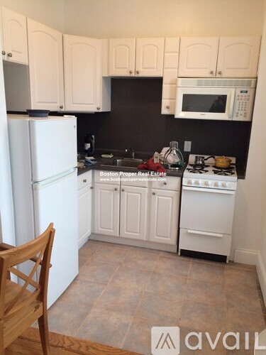 A kitchen with white appliances and cabinets.