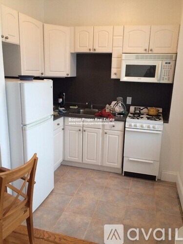 A kitchen with white appliances and cabinets.