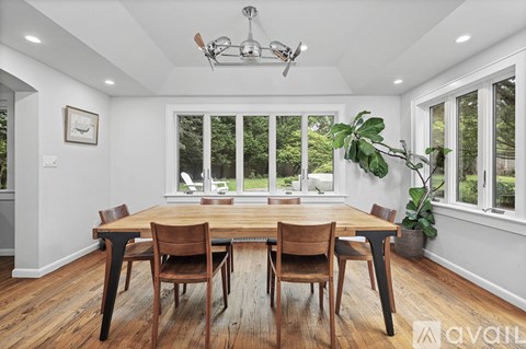 A dining room with a wooden table and chairs.